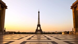 Der Eiffelturm, betrachtet von einem Platz mit geometrischen Fliesenmustern.