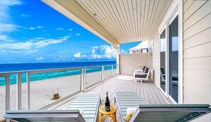 Ein Balkon mit Blick auf den Strand und das Meer.