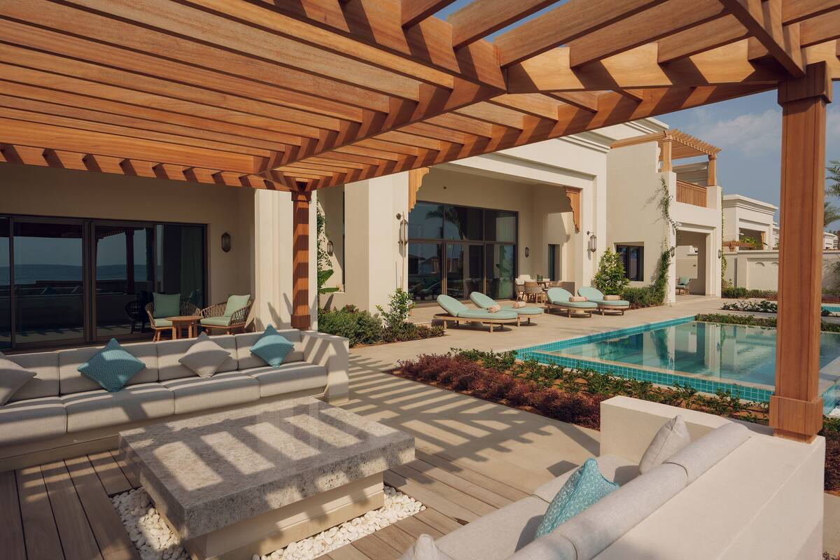 Ein moderner Außenbereich mit Pool, Holz-Pergola und Gartenmöbeln.