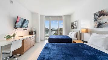 Escritorio, tabla de planchar con plancha, wifi y ropa de cama