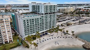 Un hôtel moderne à plusieurs étages, doté d’une piscine sur le toit et situé en bord de mer.