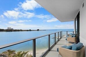 Un balcón con sillones de mimbre y vista al mar.