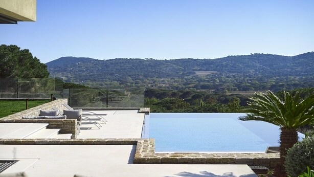 A rooftop infinity pool with a clear view of the surrounding hills.