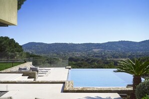 Une piscine à débordement située sur le toit, offrant une vue dégagée sur les collines environnantes.