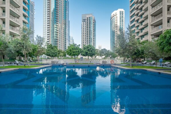 Residents can enjoy a refreshing swim in the pool surrounded by lush greenery.