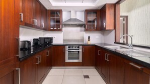 A modern kitchen with wooden cabinets, stainless steel appliances, and a large window.
