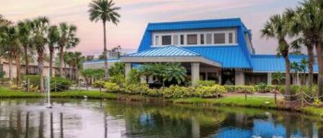 A building with a blue roof and a reflection in the water.