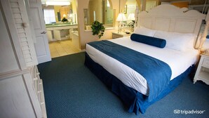 A hotel room with a large bed, a bathroom with a mirror, and a view of the hallway. - Aqua Sol is a fun family adventure! (Winter Garden)