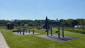 A park with exercise equipment, a slide, and a gazebo. - Myana Nest (Lowestoft)