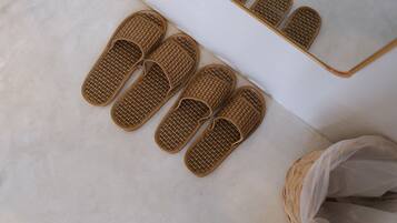 A pair of woven slippers on a white floor.