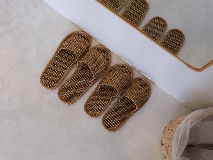 Weven slippers op een witte vloer.