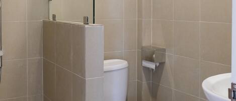 A bathroom with a shower, toilet, and sink.