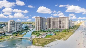 A coastal resort area with high-rise buildings, a beach, and a river.