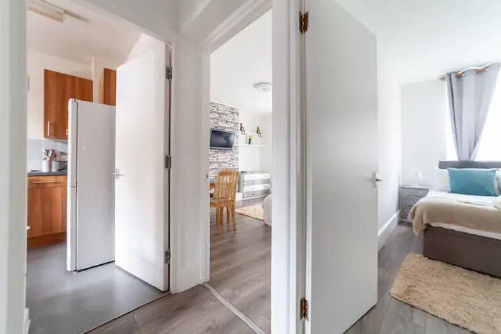Un appartement moderne comprenant une cuisine, un coin repas et une chambre.