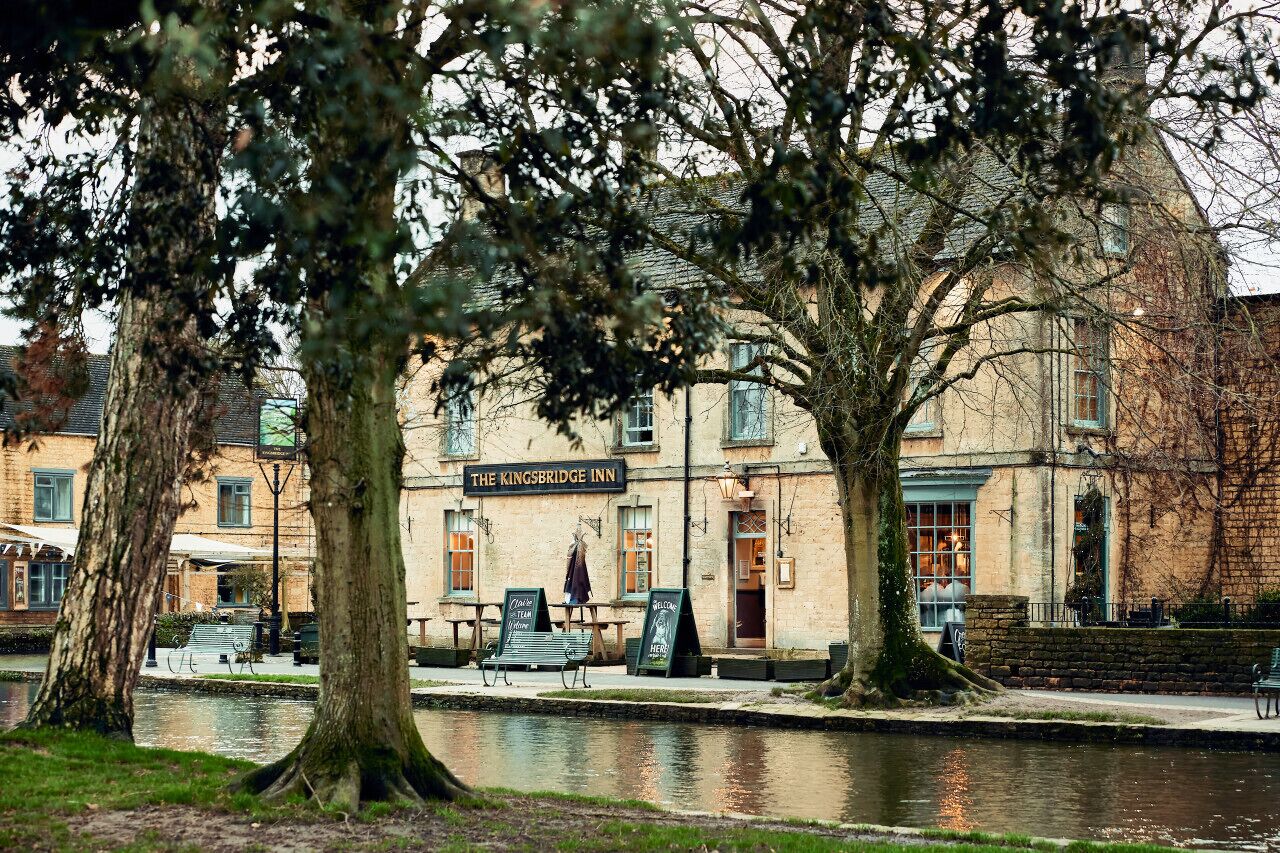 The Kingsbridge Inn with outdoor seating by a canal.