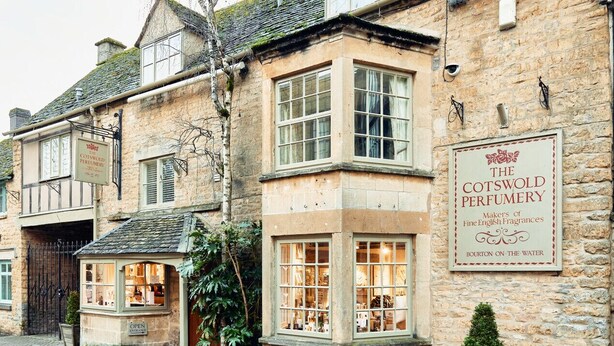 The Cotswold Perfumery, a stone building with large windows and a sign indicating it is a makers of fine English fragrances.