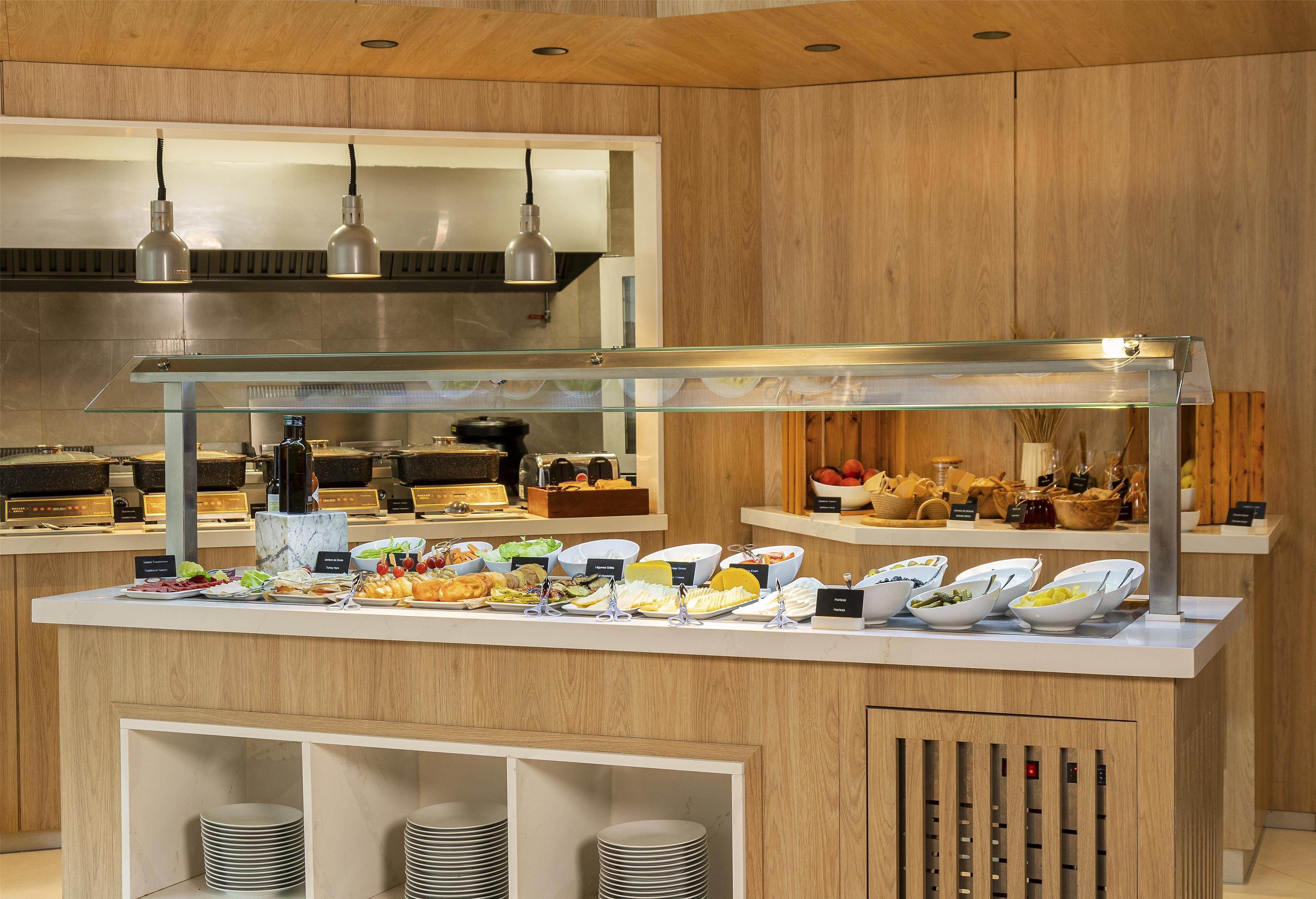 Una mesa de buffet con diversos alimentos y una vitrina de vidrio.