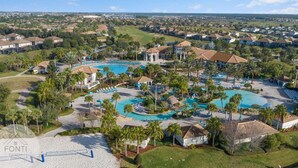 A resort with multiple swimming pools, palm trees, and a golf course in the background. - 1028L Resort 4BR Pool House FREE Grill by Disney (Kissimmee)