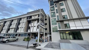 Un edificio de varios pisos con un diseño arquitectónico moderno, que combina balcones y grandes ventanales.