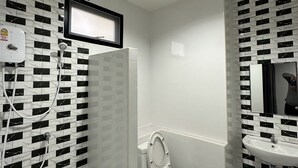 Un baño moderno con inodoro, lavamanos y ducha.