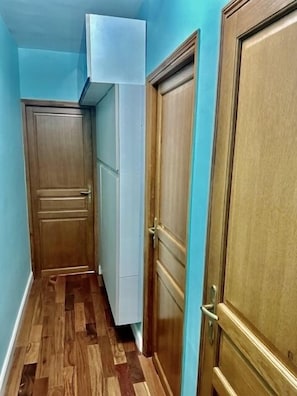 Traditional doors and a storage unit line this hallway.