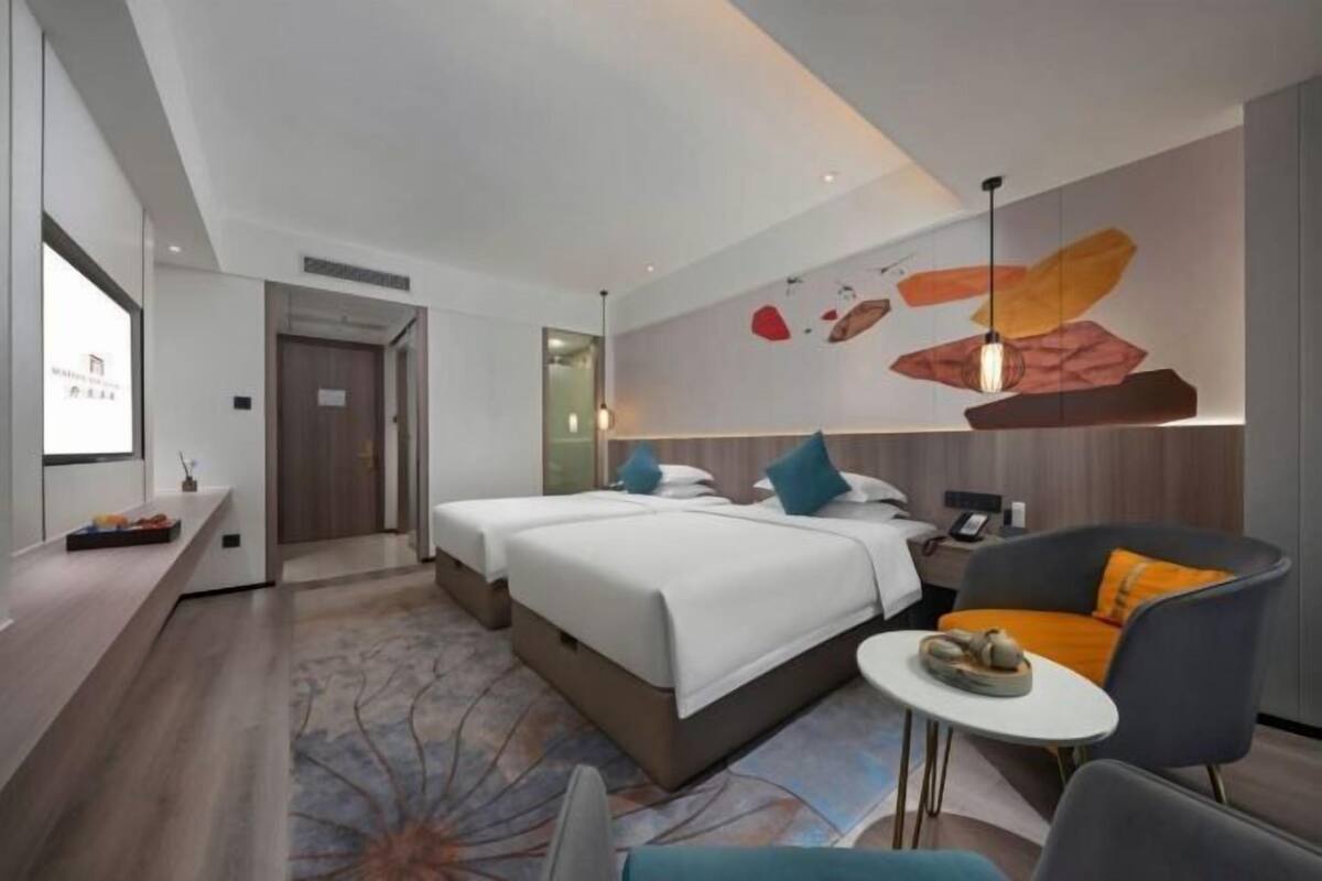 Et moderne hotelværelse med en stor seng, et skrivebord, et lille bord og en sofa.