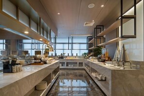 A modern hotel lobby with a central marble fountain, long reception counters, and large windows allowing natural light.
