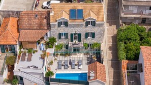 A multi-story building with a rooftop pool, stone facade, and green shutters. - Villa Filipetti in Makarska center, 4 en-suite bedrooms, heated private pool, 500m from beach (Makarska)