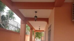 Un pasillo con piso de baldosas, techo con lámpara y pared con un panel decorativo.