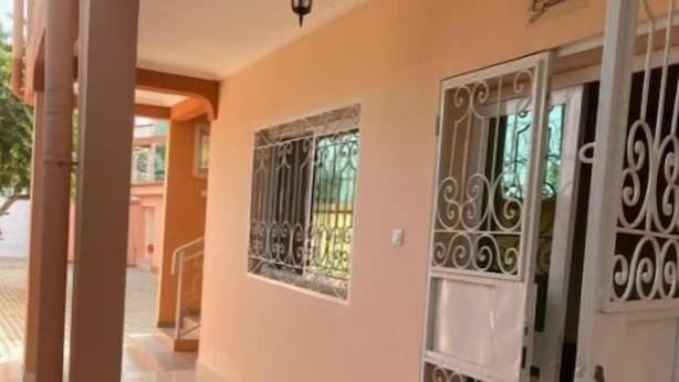 Un pasillo con piso de baldosas, una puerta con barrotes decorativos y una pared con un letrero que dice "Gadisa".