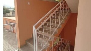 Una escalera con barandales blancos ornamentales y un ventanal en la parte superior.