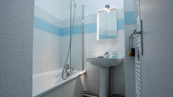 A bathroom with a bathtub, a sink, and a shower.