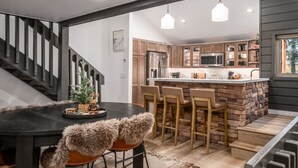 Une cuisine moderne dotée d’un îlot central, de meubles en bois et d’un réfrigérateur en acier inoxydable.