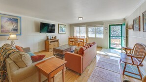 A spacious living room with a sofa, coffee table, and dining area. - Main Street Red River Condo w/ Fireplace & Views! (Red River)