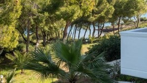 A stone pathway leading to a white building with a view of a coastal landscape. - Sounio Golden View Villas (Lavreotiki)