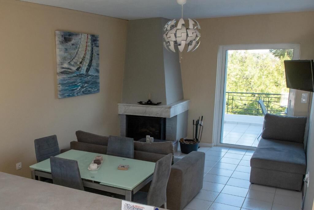 A living room with a fireplace, a dining table, and a sofa.