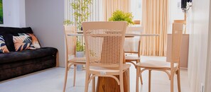 Una sala de estar moderna con un sofá, dos sillones, una mesa y una planta en maceta.