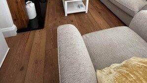 A modern living room with a wooden coffee table, two sofas, and a fireplace. - Beach retreat! (Pakefield)