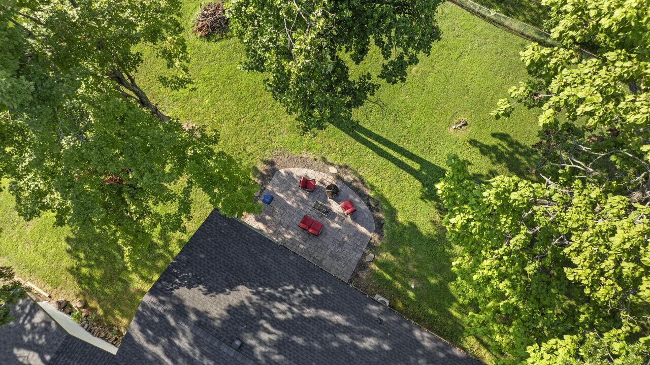 An aerial view of a rooftop patio with a circular seating area and a small garden.