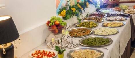 A buffet table with various dishes and a decorative wall in the background.