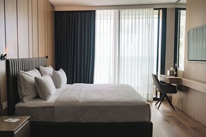 A hotel room with a large bed, a desk, and a TV. - ALMERA  (Bat Yam)