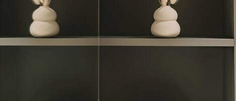 A shelf with two vases of pampas grass and two containers with the brand name "ALMEPA".