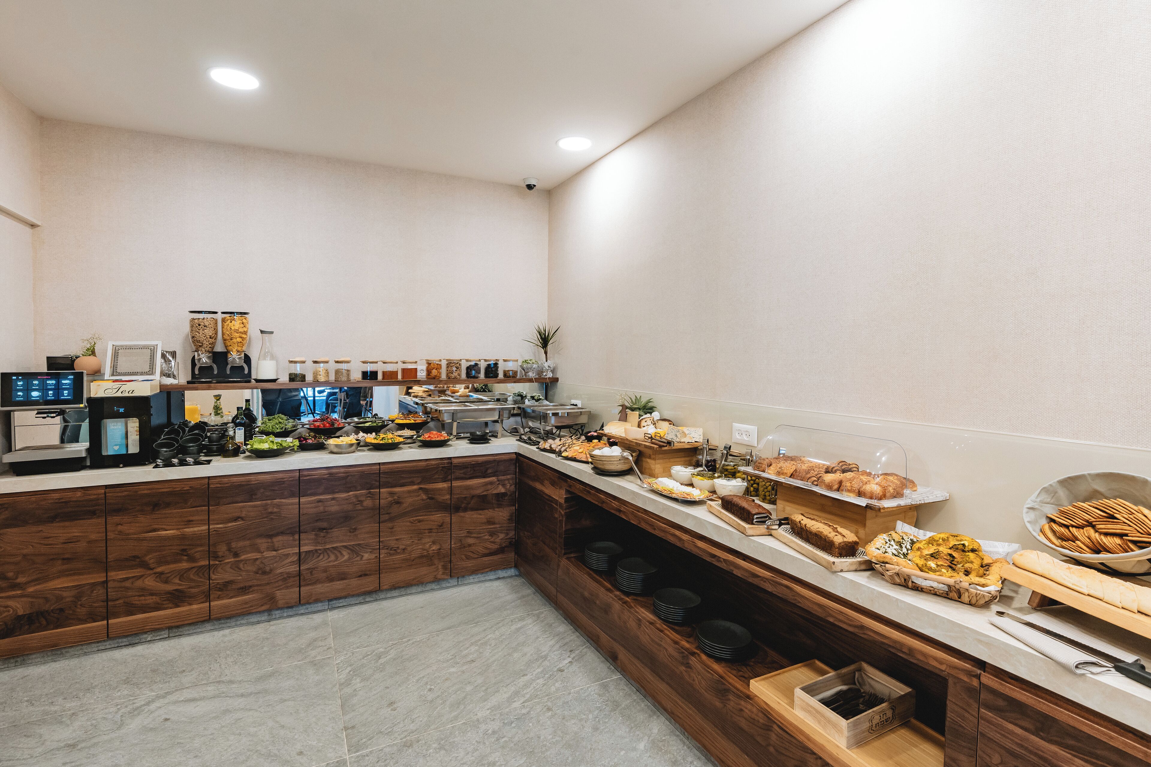 A buffet setup with various food items and a coffee machine.