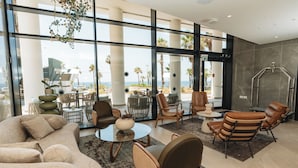 Un salón moderno con ventanas amplias, asientos cómodos y vista al océano.