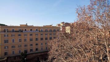 Ein mehrstöckiges Gebäude mit einheitlicher Fassade, großen Fenstern und einem Balkon in den oberen Etagen.