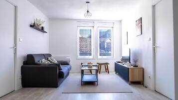 A modern living room with a sofa, a coffee table, and a TV stand.