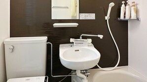A modern bathroom with a toilet, sink, and bathtub. - Izumisano Home (Izumisano)