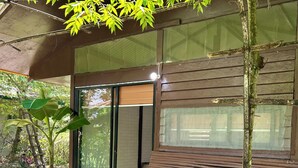 Un banco de madera, una planta en maceta y un edificio con puerta corredera de vidrio.