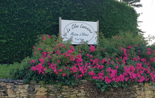 Welcome to Le Clos Lascazes, a charming retreat surrounded by lush greenery and vibrant flowers.