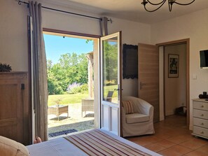 Relax in this serene room with a sliding glass door leading to an outdoor area, a comfortable bed, and a dresser for your belongings.
